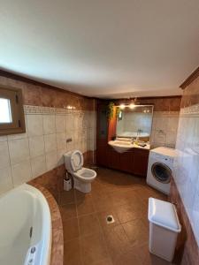 a bathroom with a tub and a toilet and a sink at Villa Ocean in Paralia Dionysiou