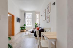 - un salon aux murs blancs avec une table et des chaises dans l'établissement Romantic apartment by the park - uaka7, à Prague