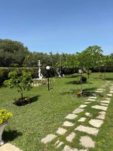 a garden with a stone path in the grass at Villa Ocean in Paralia Dionysiou