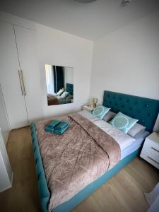 a large bed with a blue headboard in a bedroom at White Pearl Apart in Rogowo