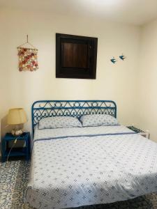 a bedroom with a blue bed with a white bedspread at Villa by the Vulcano - 55 mq plus large garden and patio in Vulcano