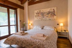 a bedroom with a large bed with two towels on it at Cascina Girba in Giaveno