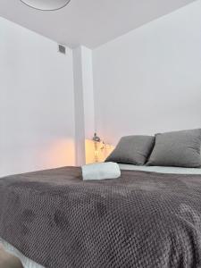 1 dormitorio con 1 cama con edredón marrón en SumaLoft Prensa, en Málaga 18 fotos más