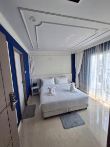 a bedroom with a large white bed with blue walls at V.I.P BOUTIQUE HOTEL in Vientiane