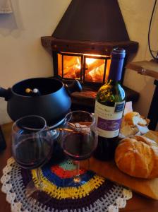 a table with a bottle of wine and two glasses at ACasA in Gonçalves
