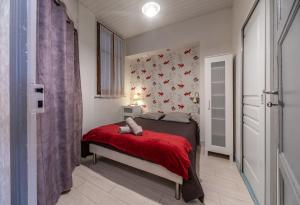 ein Schlafzimmer mit einem Bett mit einer roten Decke in der Unterkunft Le Lasteyras - Appartement charmant en centre ville in Vichy