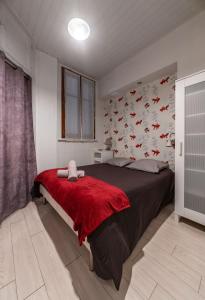 ein Schlafzimmer mit einem großen Bett mit einer roten Decke in der Unterkunft Le Lasteyras - Appartement charmant en centre ville in Vichy