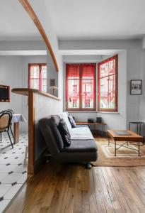 ein Wohnzimmer mit einem Sofa und einem Tisch in der Unterkunft Le Lasteyras - Appartement charmant en centre ville in Vichy