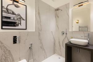 Un baño con un lavabo y un coche en la pared. en Eden Rooms, en Stresa
