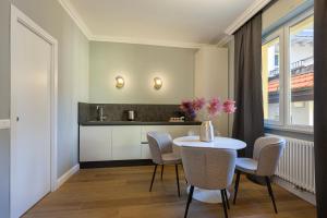 Un comedor con mesa y sillas y una cocina. en Eden Rooms, en Stresa