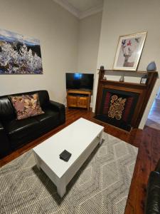 a living room with a couch and a coffee table at Arden on McLachlan in Orange