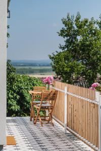 a wooden table and bench on a fence with flowers at Barrique - Somló Country Home in Somlóvásárhely