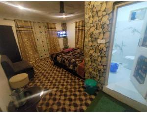 Hotel The Gulmarg Gateway Resort, Jammu and Kashmir في Tangmarg: غرفة بسرير ونافذة