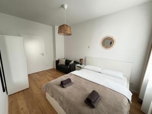 a white bedroom with a large bed and a couch at 60qm - 2 rooms - free parking - city - MalliBase Apartments in Hannover