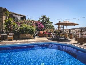 a swimming pool in front of a house at Cyprus Villages Hotel & Restaurant - Central Location - Bed & Breakfast - With Access To Pool And Stunning Views in Tochni