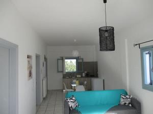 a living room with a blue couch and a window at House in vineyard in Emboríon