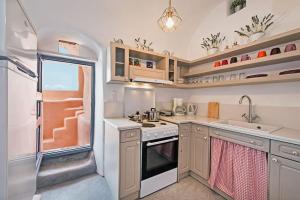 cocina con fogones y fregadero en Oia Breeze House, en Oia 10 fotos más