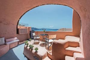 Una vista de un balcón con una mesa y sillas. en Oia Breeze House, en Oia