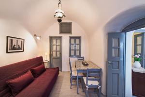 una sala de estar con un sofá y una mesa en Oia Breeze House, en Oia
