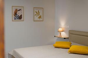 um quarto com uma cama com almofadas amarelas e um candeeiro em Arches em Agria