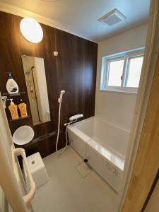 ein Bad mit einem Waschbecken und einem Spiegel in der Unterkunft ツナゲル青森安方annex in Aomori