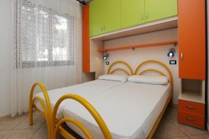 a bedroom with a bed with orange and green walls at Villa Adriana in Rosolina Mare