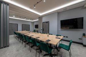 a large conference room with a long table and green chairs at Sandman Signature Glasgow Hotel in Glasgow