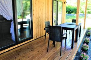 a porch with a table and chairs on a deck at Yatsugatake Guest House Matsuda House - Vacation STAY 11086 in Hokuto