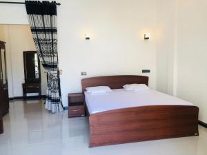 1 dormitorio con 1 cama grande con sábanas blancas en Crocotopond, en Arugam Bay