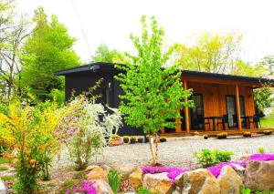 ein Haus mit Garten davor in der Unterkunft Yatsugatake Guest House Matsuda House - Vacation STAY 11086 in Hokuto