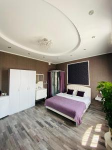 1 dormitorio con 1 cama grande con manta morada en Готель Лаванда на Ривьере , Карпатский чан, Фонтанка 1 Одесса, en Fontanka