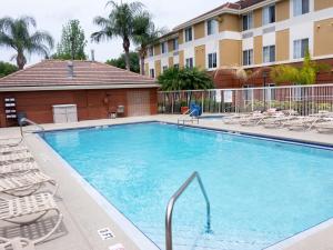 a large swimming pool with chairs and a building at Extended Stay America Suites - Orlando - Lake Buena Vista in Orlando