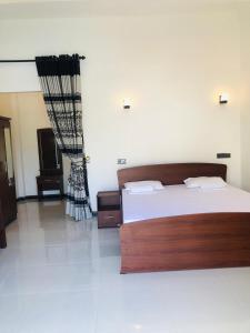 1 dormitorio con 1 cama grande y cabecero de madera en Crocotopond, en Arugam Bay