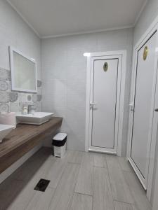 a white bathroom with a sink and a door at Pansion Speranza Međugorje in Međugorje