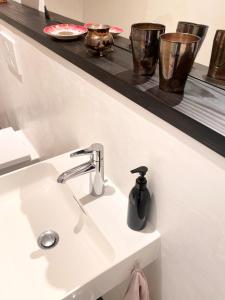 ein Waschbecken mit einem Seifenspender auf einem Regal in der Unterkunft Zehuus Beletage in Köln + 18 Fotos