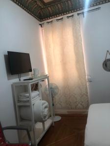 um quarto com uma secretária, um computador e uma cortina em Grand Via House em Madri