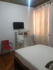 um quarto com uma cama e uma secretária com uma televisão em Grand Via House em Madri