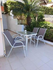 un tavolo bianco e sedie su un patio di Country Escape 2 Bd Crete Apt with Scenic Patio a Kalo Chorio