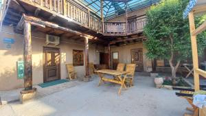 an outdoor patio with a wooden table and chairs at B&B, Khiva ,, Abdullah " in ichan Kala in Khiva