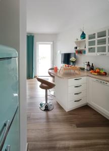 una cucina con armadietti bianchi e pavimenti in legno di Wishing & Dreaming Sperlonga a Sperlonga