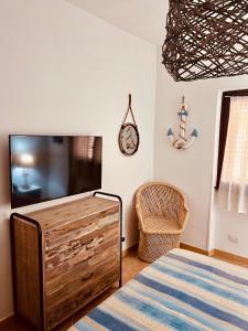 ラ・マッダレーナにあるIl Maestrale - Cala Chiesaのベッドルーム(ベッド1台、テレビ、椅子付)