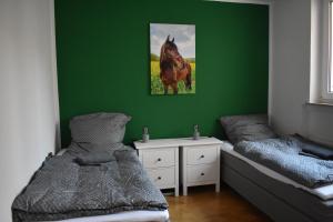 a bedroom with two beds and a green wall at Ferienwohnung Rhönmarkt in Ostheim