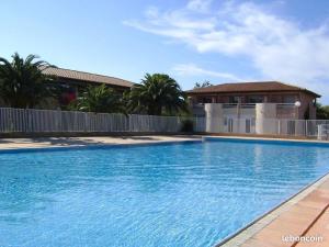 ein großer blauer Pool vor einem Haus in der Unterkunft Pierres de Jade Maison de vacances en residence avec piscine in Saint-Cyprien