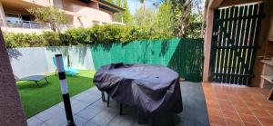 eine Terrasse mit einem Tisch und einer Plane darauf in der Unterkunft Pierres de Jade Maison de vacances en residence avec piscine in Saint-Cyprien