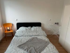1 dormitorio con 1 cama con manta y lámpara en Wohnung über Restaurant en Alsdorf