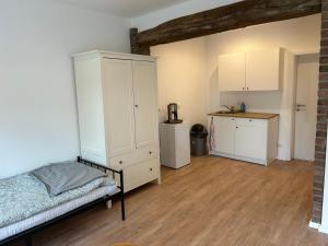 1 dormitorio con 1 cama y armario blanco en Wohnung über Restaurant en Alsdorf