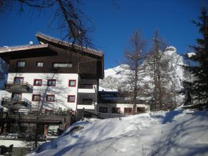a building in the snow with a mountain at Contemporary Apartment in Breuil Cervinia near Ski Area in Breuil-Cervinia