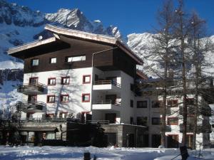 a building in the snow with mountains in the background at Contemporary Apartment in Breuil Cervinia near Ski Area in Breuil-Cervinia