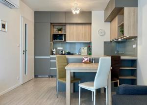 cocina con mesa de madera y sillas en Central Stay en Nivy