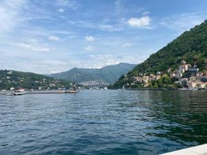 vista su un lago con città e montagne di LA CASA NEL BOSCO, DI MARI ad Appiano Gentile